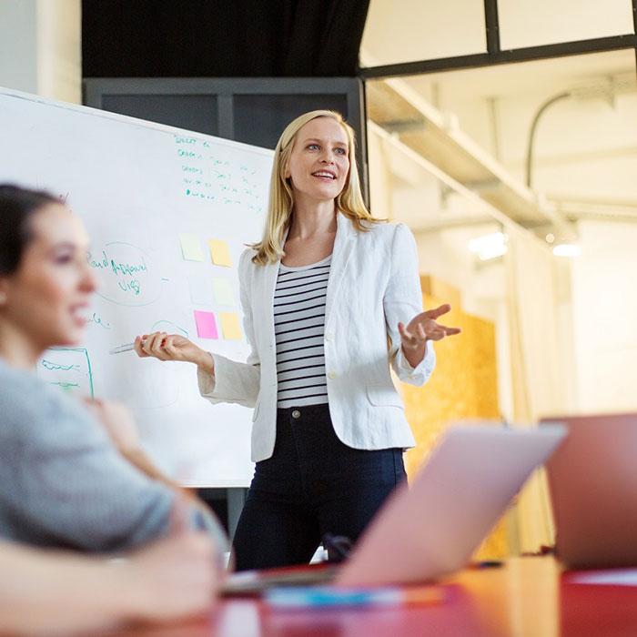 HR manager presenting in front of whiteboard to staff