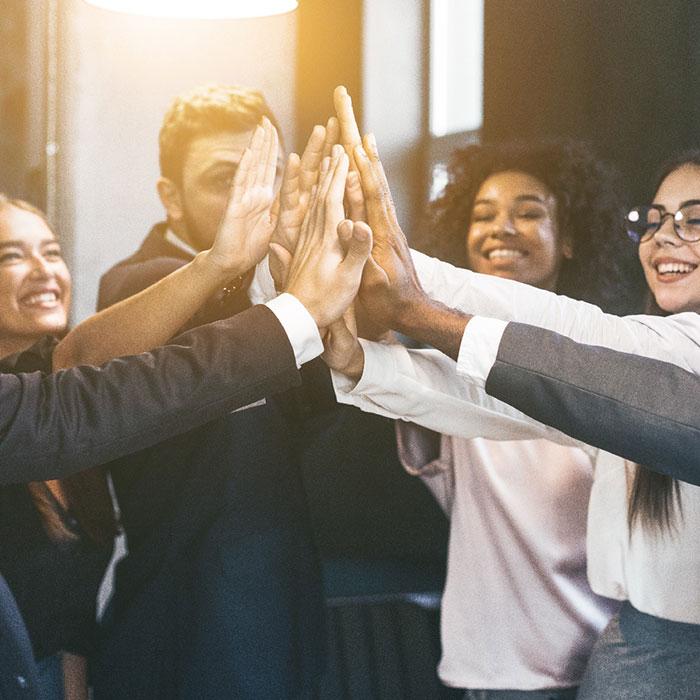 Men and women work colleagues highfiving each other