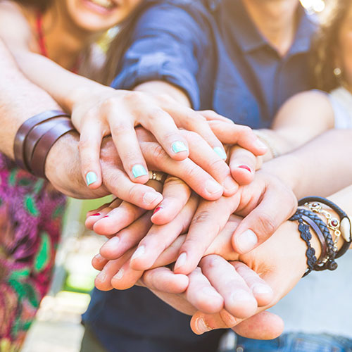Closeup of employees with hands together